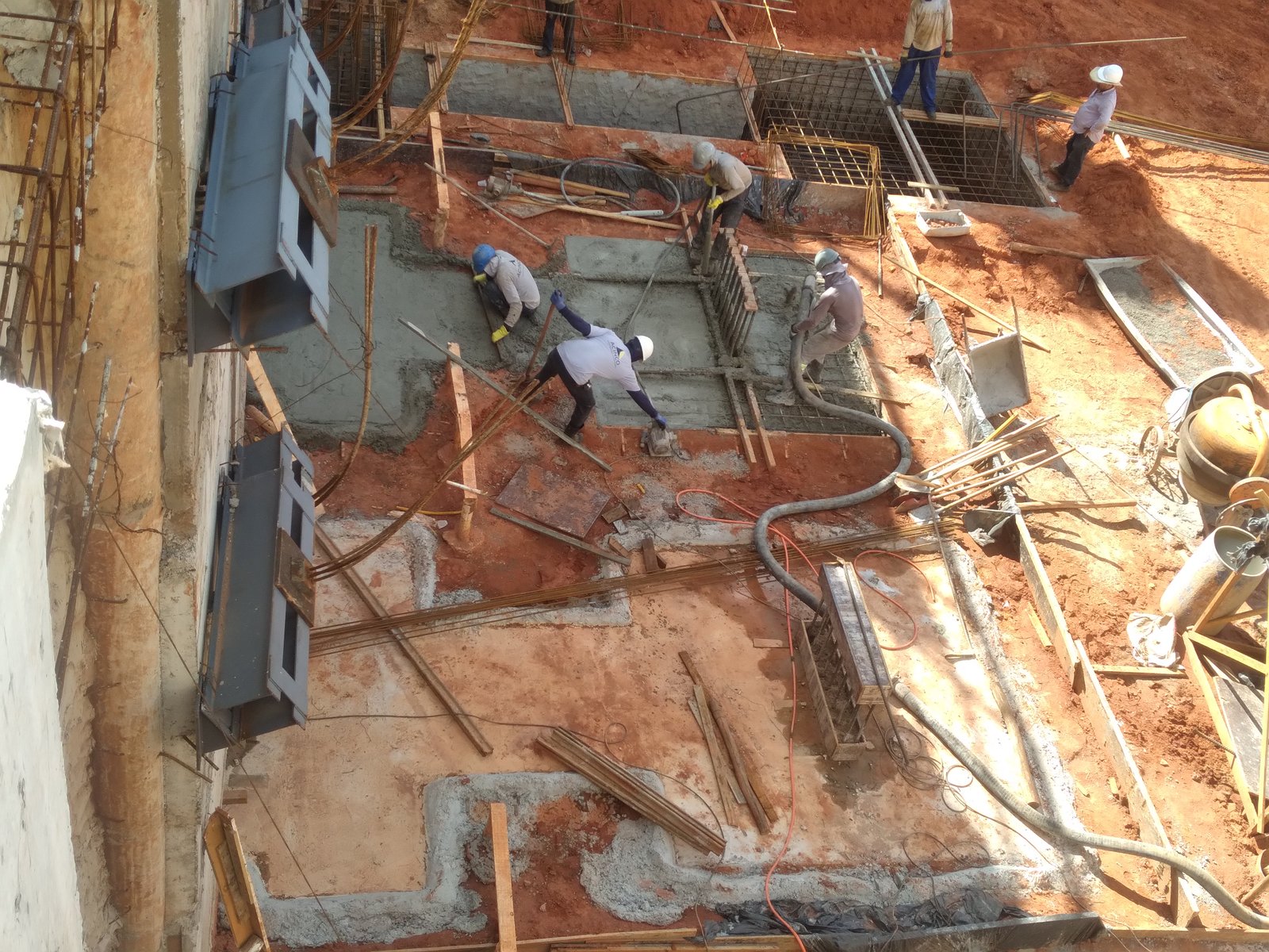 Vista aérea da concretagem de laje com equipe finalizando o acabamento